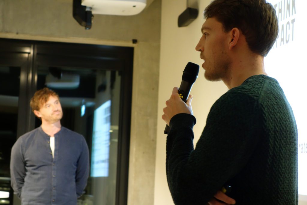 At the front, Florian discusses finding a cofounder in the climate tech space and Michael, visible in the background, listens.
