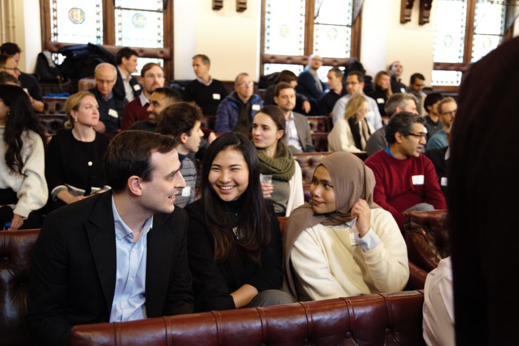 our cohort 3 climate tech founders and the audience sit in the Cambridge Union chatting